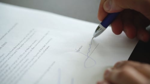 Homme d'affaires assis au bureau signant un contrat avec un accent superficiel sur la signature