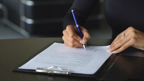 Adult Signing a Business Agreement in Office
