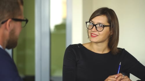 Woman Discussing Business with Colleague in Office
