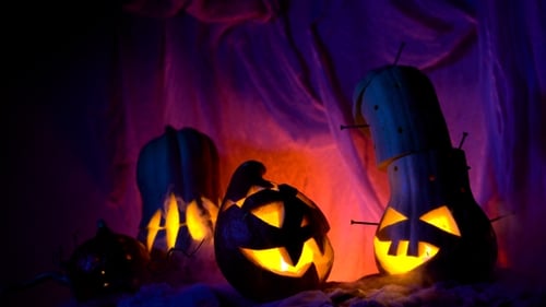 Glowing Jack-o-Lanterns and Squash Figures in Dark Setting