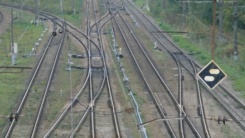 Empty Railroad Track With Some Train Switches and Electrical Wires Leading Off Into the Distance