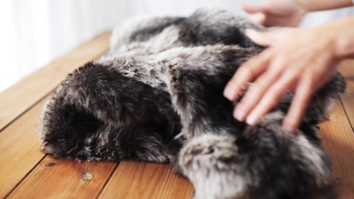 Veste femme en fausse fourrure pliante sur table à la maison
