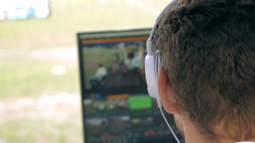 Person in Headphones Watching Live Broadcast on Computer