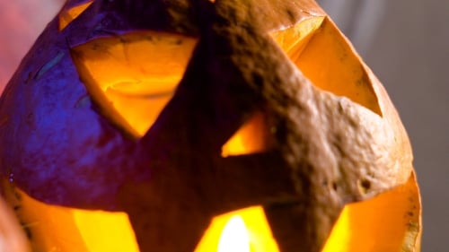 Pumpkin Head Lit From Within, Her Eyes, Nose And Mouth Flickering Candle Light. All Saints Day
