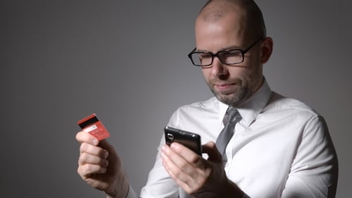 A Man With a Beard Businessman Holding a Mobile Phone And The Hands Of The Credit Card.