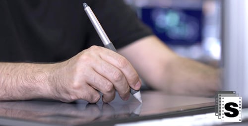 Digital Artist Using Stylus and Tablet at Workstation