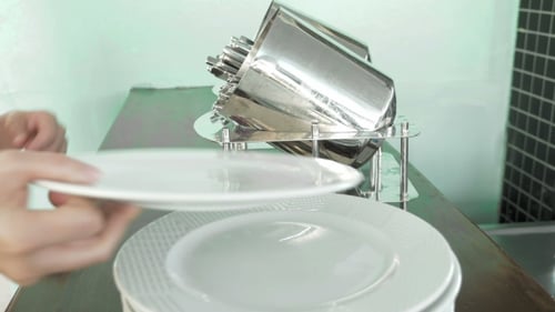 Hands Preparing Table Setting with Plates and Utensils