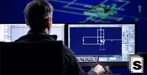 Engineer Designs on Multiple Computer Screens at Desk