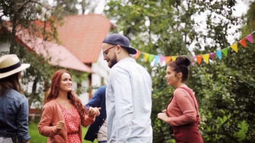 Amigos felizes dançando na festa de verão no jardim
