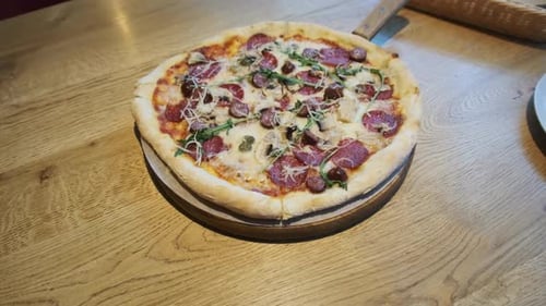 Pizza recién preparada sobre una mesa de madera en un café