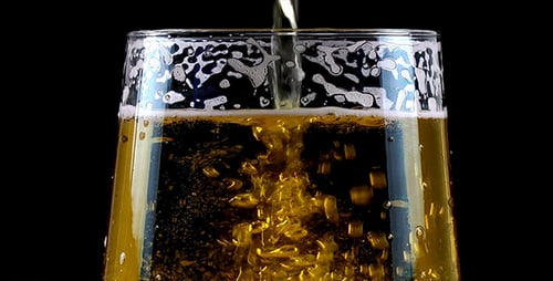 Golden Beer Pouring Into Glass on Black