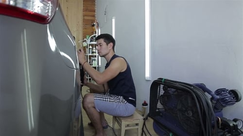 Young Adult Buffing Car Body with Power Tool
