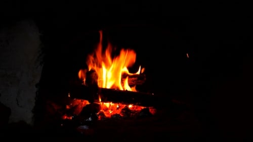 Feuer brennt in einem rustikalen Holzofen
