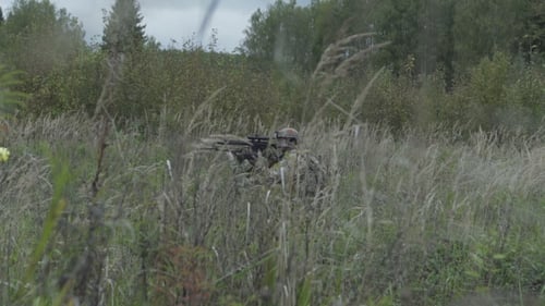 Soldier With Weapon In Hand Goes On The Grass