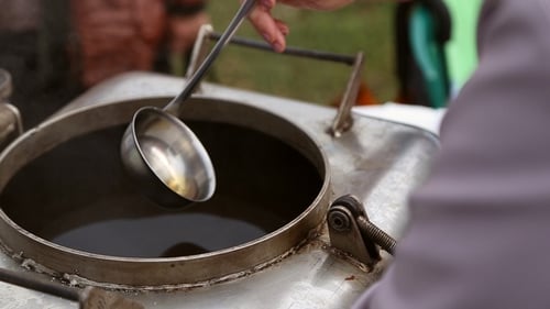 Une femme verse une louche compote dans un verre