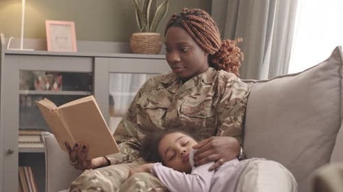 Loving Mother Reading While Child Sleeps on Couch
