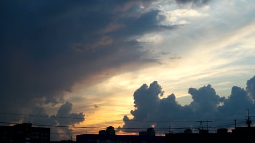 Clip Of Sunset Fluffy Clouds Over Blue Sky Over The City.