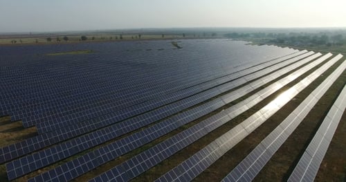 Aerial View. Flying Over The Solar Power Plant With Sun. Solar Panels And Sun. Aerial Drone Shot