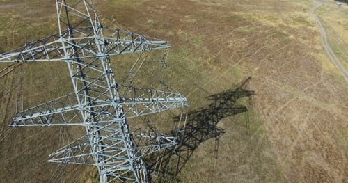 AERIAL: Flying Up The High Voltage Electricity Tower And Power Lines. Aerial Drone Shot. 30Fps