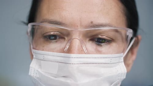 Yeux d'une femme médecin portant un masque facial et des lunettes