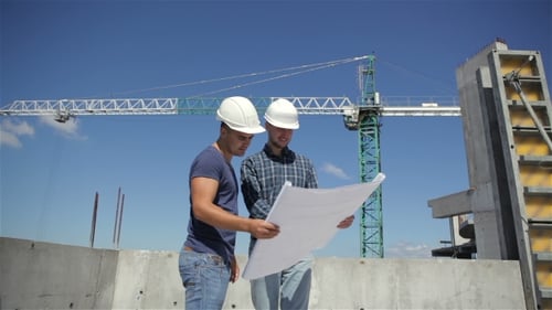 Construction Manager Points At The Plan Of Building Under Construction