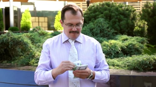 Man Counting Money Outdoors on Sunny Day