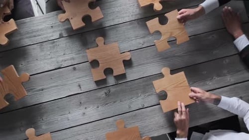 Business people team assembling puzzle