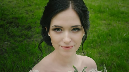 Beautiful Bride Smiling with Flower Bouquet in Green Field