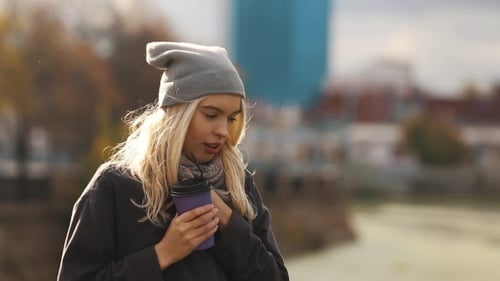 Beautiful Young Woman With a Cup Of Coffee In The Autumn City. Warmed By Hot Coffee.