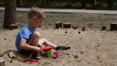 Young Boy Playing with Sand Toys Outdoors
