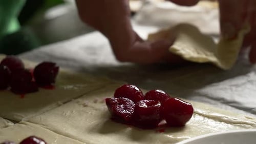 Cherries Being Placed Inside Dough for Baking