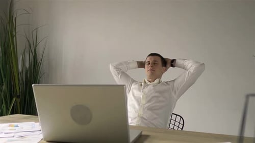 Young Adult Relaxing at Workplace Desk