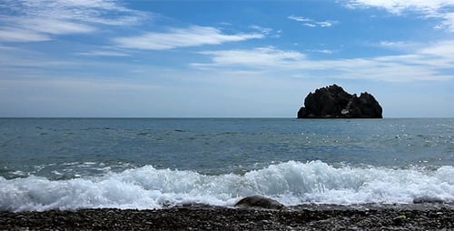 Waves Crashing on Rocky Shoreline with Island View