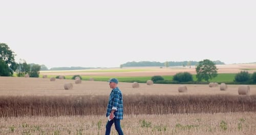 Farmer Using Digital Tablet While Examining Field