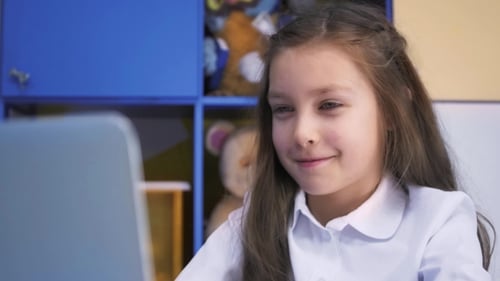 SchoolGirl Studying At The Library Doing After Lessons Homework With Laptop