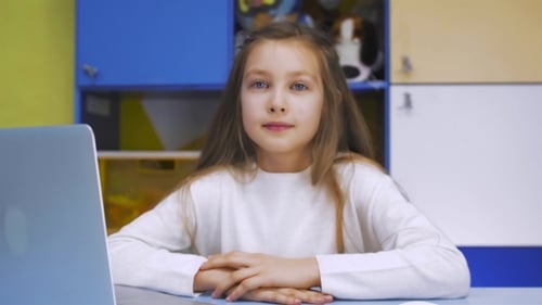 Girl Using a Laptop Computer At School. Schoolgirl After Lessons In Library