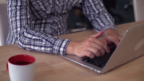 Adult Types on Laptop in Home Office