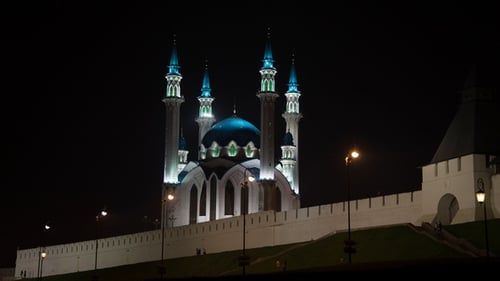 Menschen gehen nachts in der Nähe der Moschee spazieren
