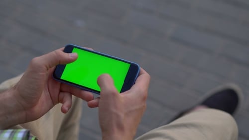 Person Playing Game on Smartphone with Green Screen