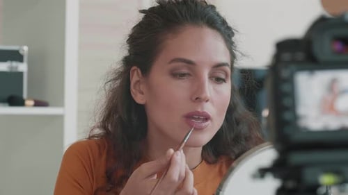 Woman Applies Makeup On Camera Indoors