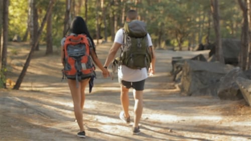 Casal de caminhantes continua a caminhar na floresta