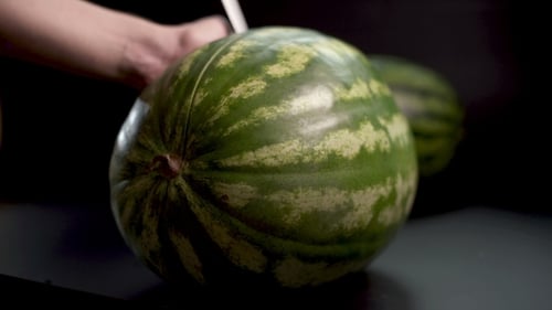 Wassermelone mit einem Messer schneiden