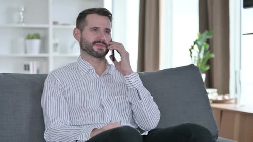 Smiling Man Talking on His Cell Phone at Home