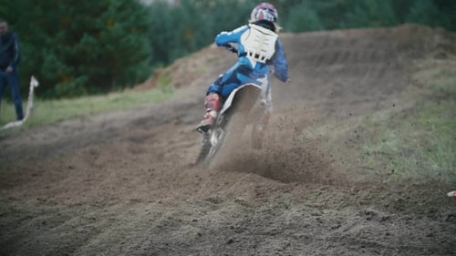 Motocross Racer Jumping. Rear View of Biker on Track in Rapid Shoot