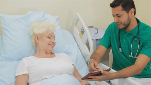 Doctor Explains Results to Elderly Woman Patient
