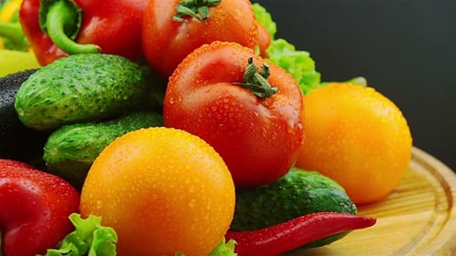 Fresh vegetables and herbs on a spinning wooden board