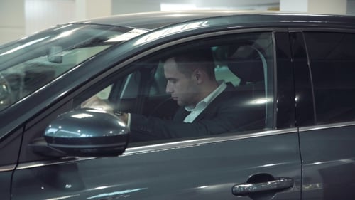 Young Adult in Suit Using Car Console