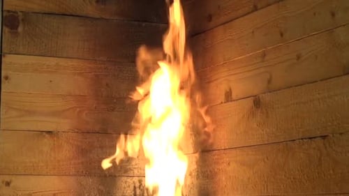 Flames Burning Violently Against a Wooden Surface