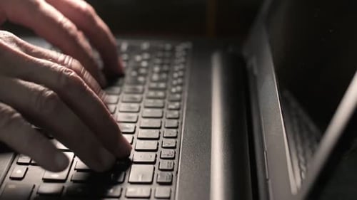 Seitenansicht männlicher Hände, die zu Hause auf der Laptoptastatur tippen