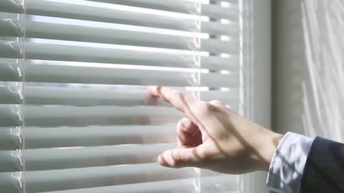 Closeup View of Man's Finger Open Blinds